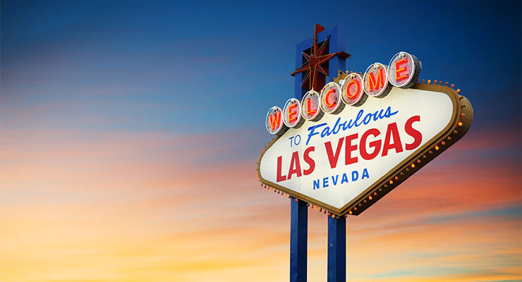 The iconic Las Vegas sign on the sunset trip, set against a luminous sky.