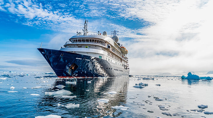 An expedition ship on an antartica cruise holiday making it's way through icy waters and glaciers.