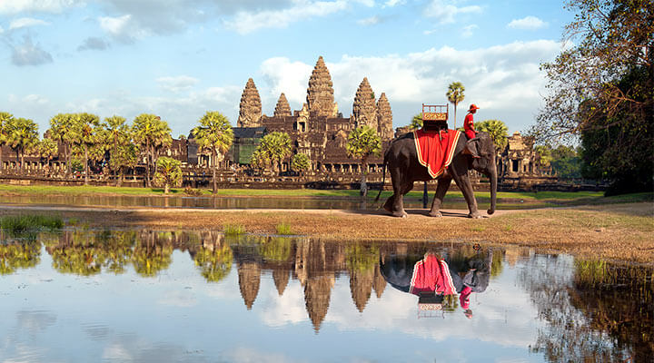 Tourists ticking off their bucket list destinations with an elephant ride in front of siam reap in Cambodia.