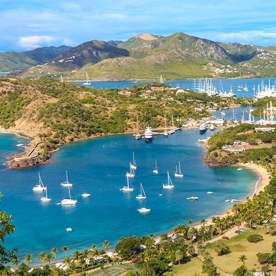 Luxury boats docking at a caribbean port in clear blue waters.