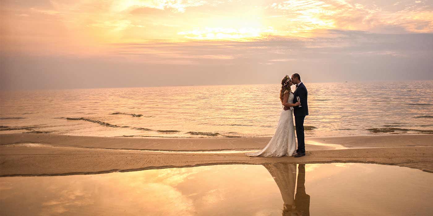 Bride and groom getting married on the beach with destination wedding packages.