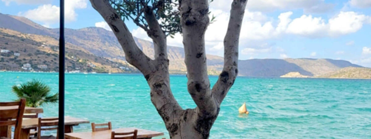 Waterfront restaurant on holiday in crete, with crystal clear blue waters.