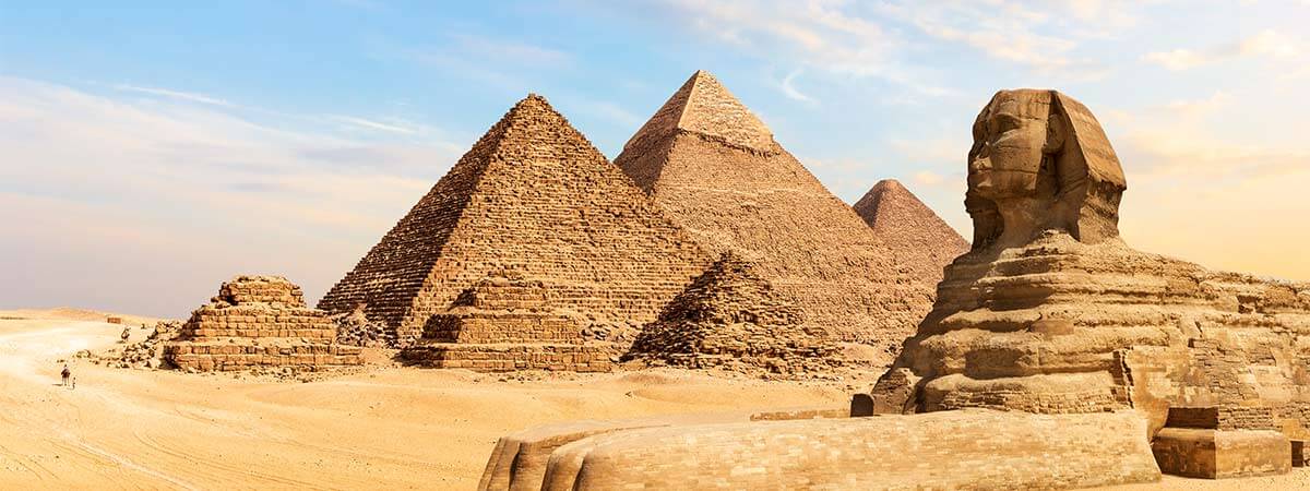 A view from afar of the majestic pyramids of giza and the sphinx, surrounded by the deserts of egypt.
