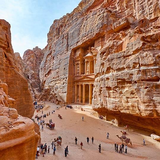 Tourists walking through the amazing destination of the lost city of Petra in Jordan.