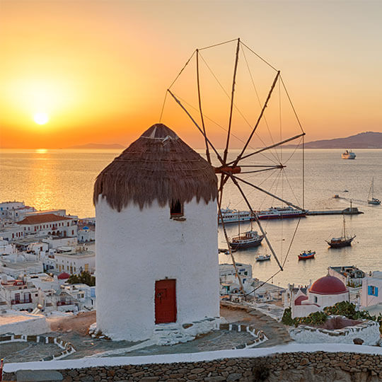 An iconic windmill on the greek island of mykonos, a popular destination for a birthday holiday, to admire the sunsets and architecture.