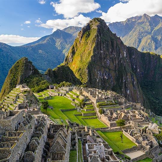 Aerial view of the peak of the Macchu Picchu trail, surrounded by mountains.