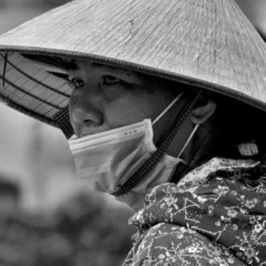 An old japanese woman wearing a face mask.