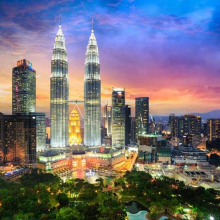 The iconic cityscape of kuala lumpur, with the petronas towers lit up against the night sky
