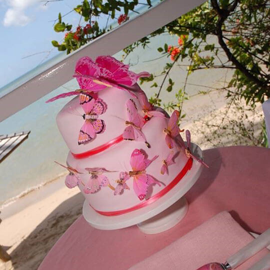 Pink wedding cake on the beach in st lucia.