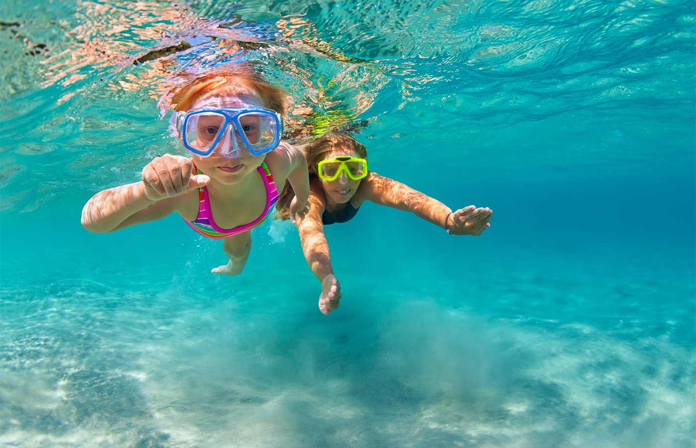 A mum and daughter snorkelling in the clear ocean on one of the best holidays for families.