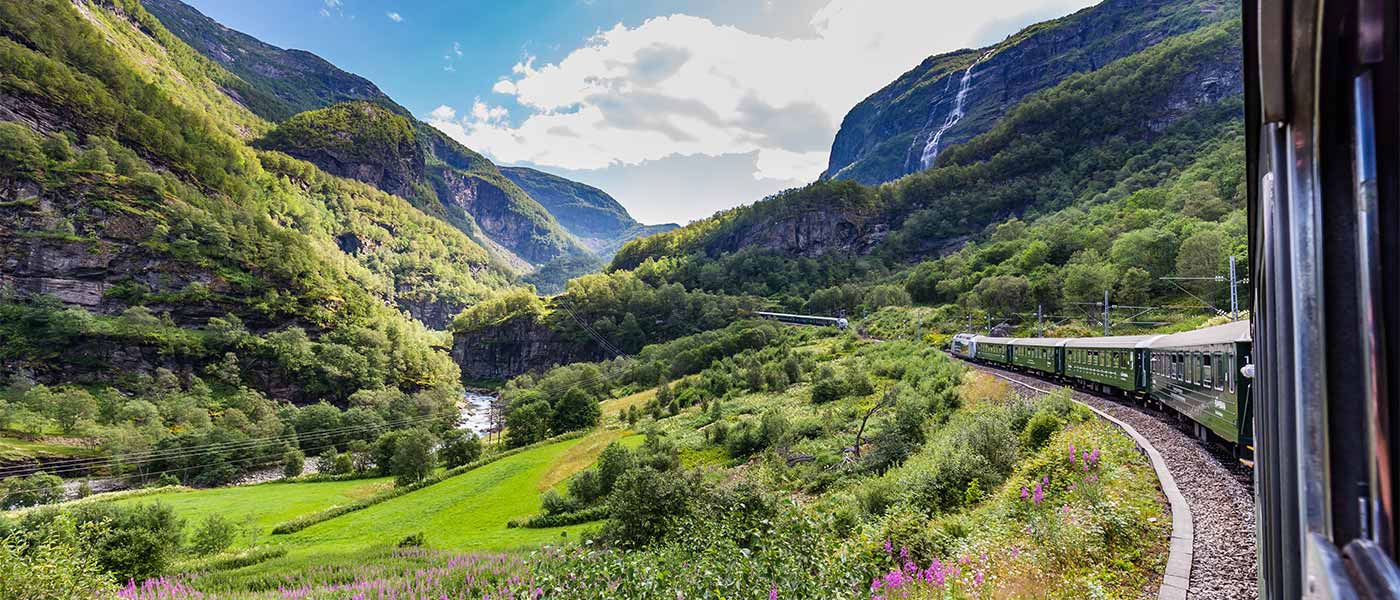 A train passing through glorious mountain and lake scenery of one of the great rail journeys of the world.