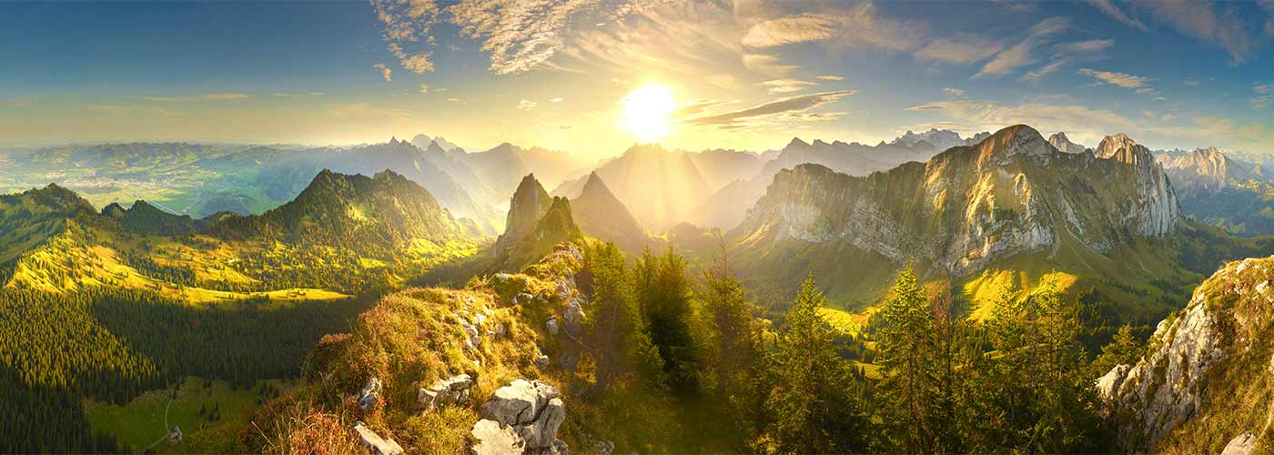 The mountain ranges of Switzerland, where people go for off the beaten track holidays, with the sun setting over the snowy peaks.
