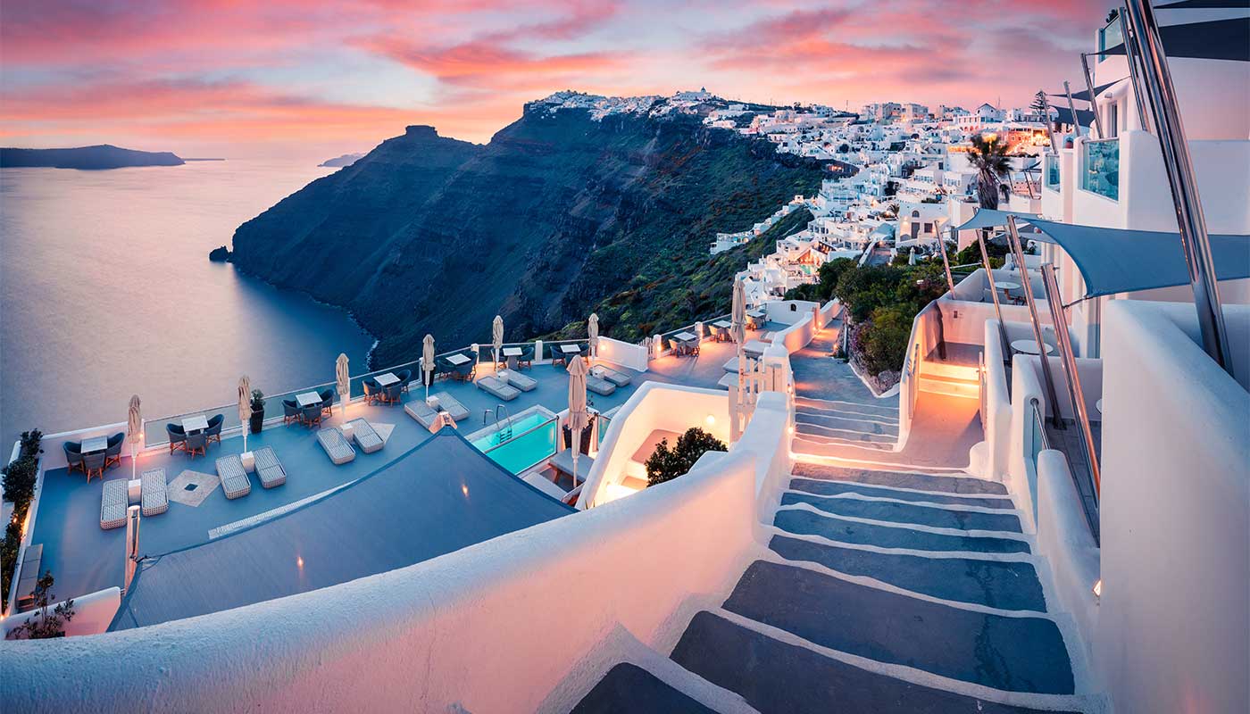 Sunset at Fira in Santorini, with pink hues lighting up the traditional white buildings.