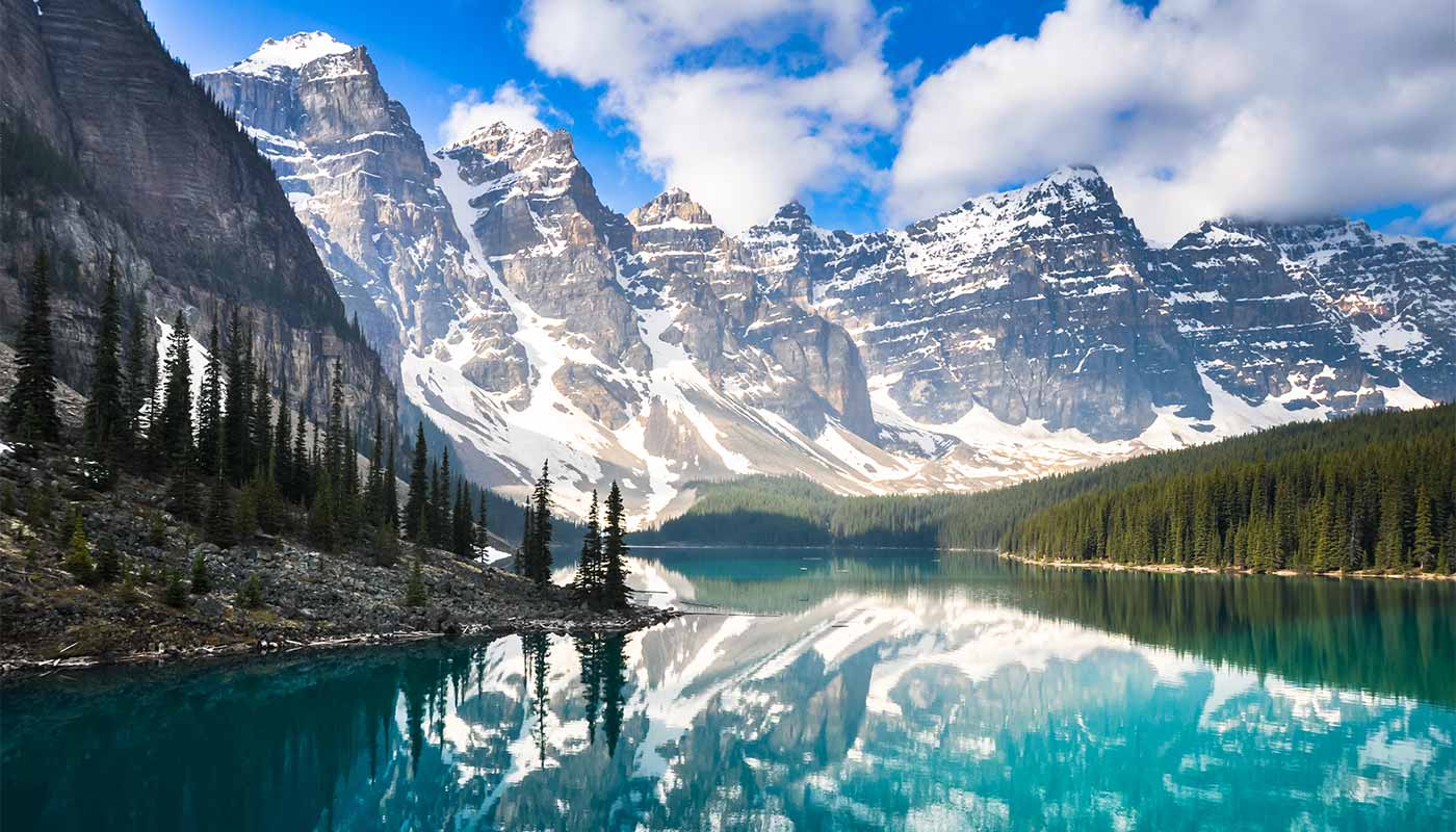 reflection of the snowy mountains in a blue lake in Banff, Canada, a popular trip for tailor made travel.