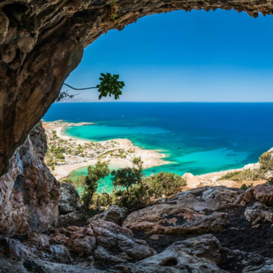 View of an exotic beach from within a coastal cave.