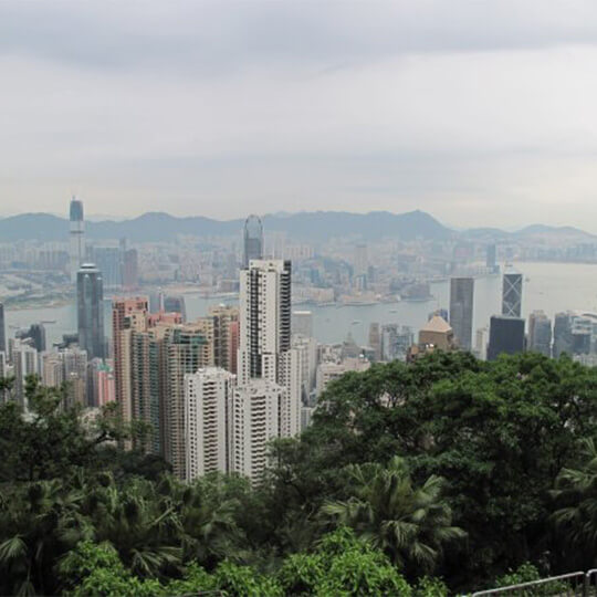 The cityscape in hong kong with a view of the mountains in the background.