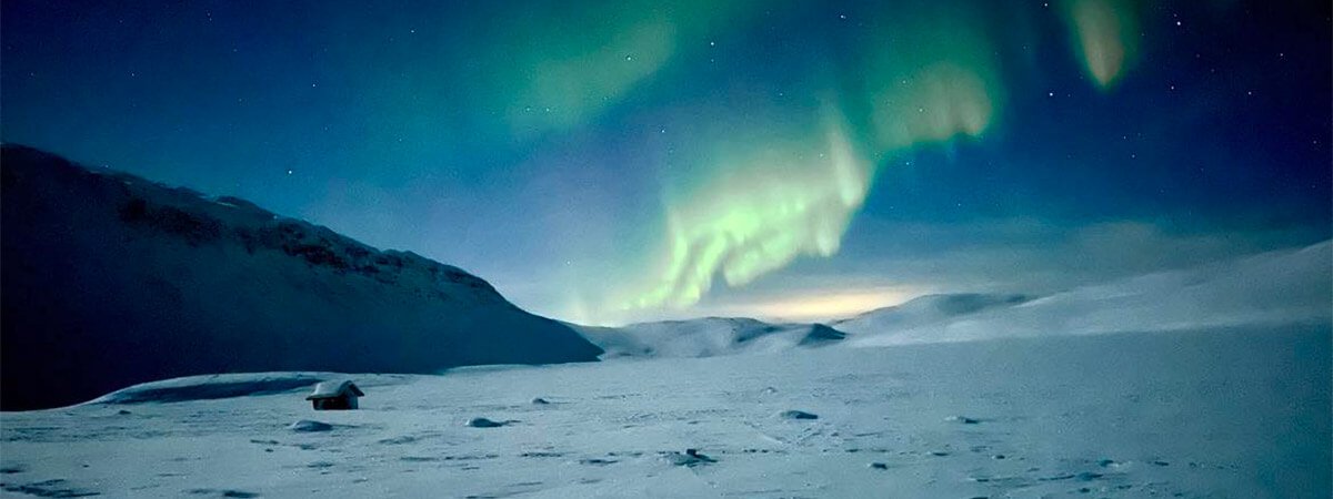 Majestic view of the northern lights over the snowy mountains on our holiday to finland.