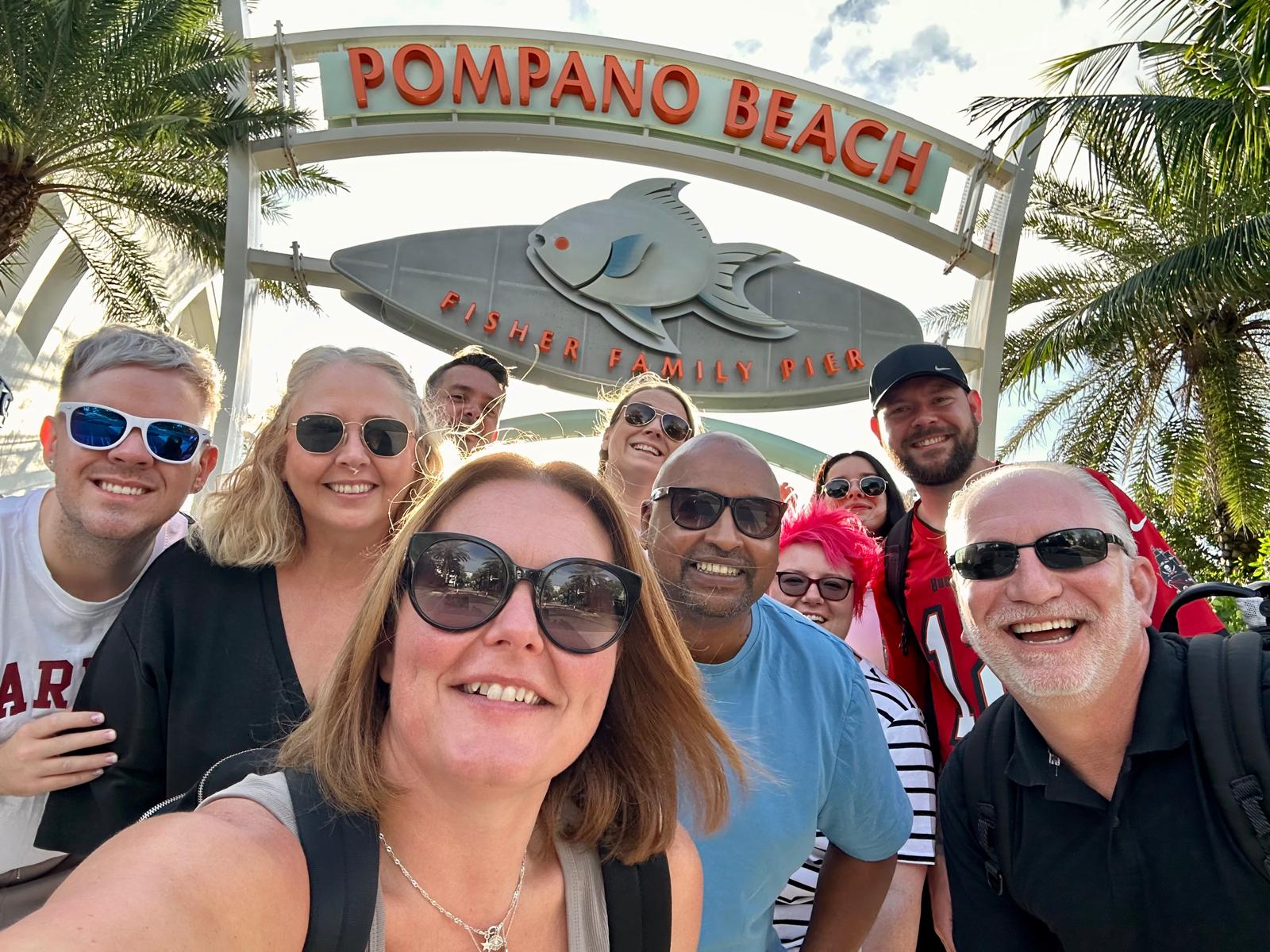 Group photo at Pompano Beach Fisher Family Pier entrance sign