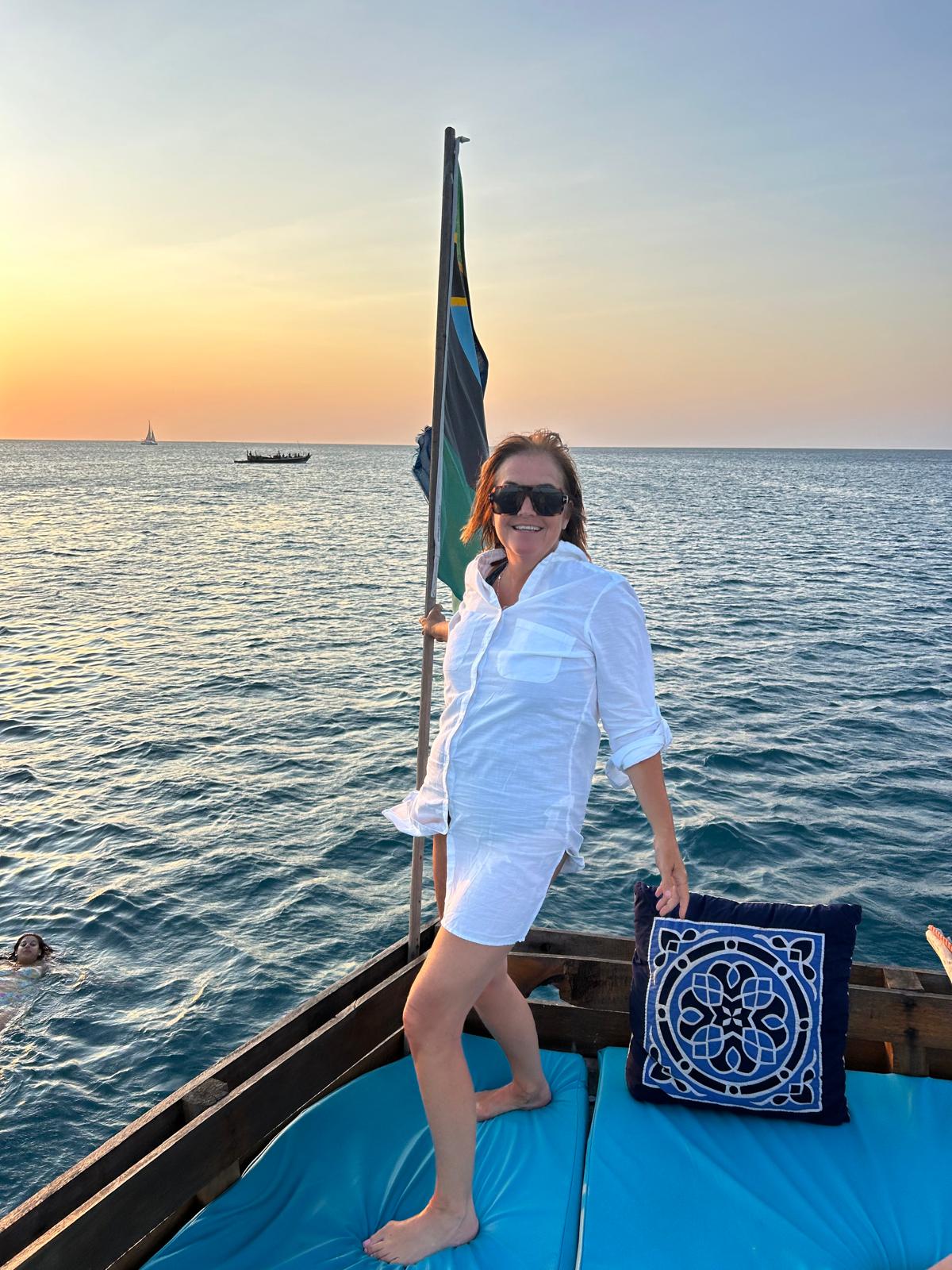 Woman enjoying sunset cruise on traditional boat with ocean view