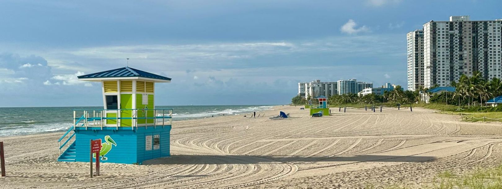 Colorful lifeguard tower on Fort Lauderdale Beach with high-rise buildings and palm trees in the background