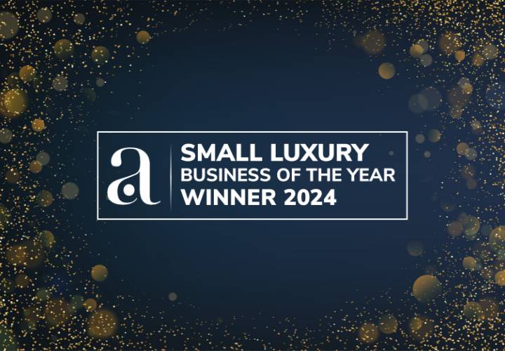 Small Luxury Business of the Year Winner 2024 award logo on dark blue background with golden sparkle effect