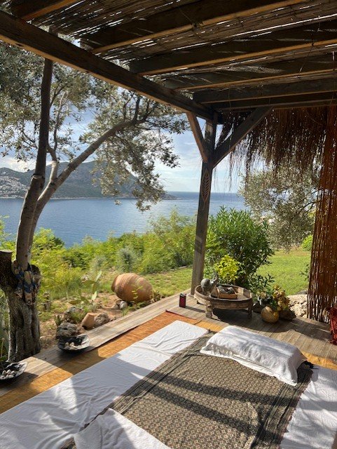 Luxury villa daybed with panoramic Turquoise Coast sea views in Kalkan Turkey, traditional pergola shading and Mediterranean garden showcasing premium villa holidays Turkey experience