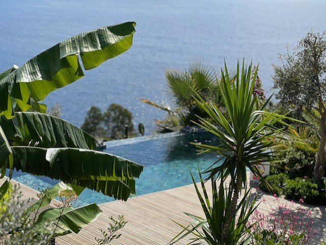 Luxury infinity pool with turquoise water and tropical plants overlooking Mediterranean Sea in Kalkan Turkey villa showcasing premium villa holidays Turkey experience with stunning views