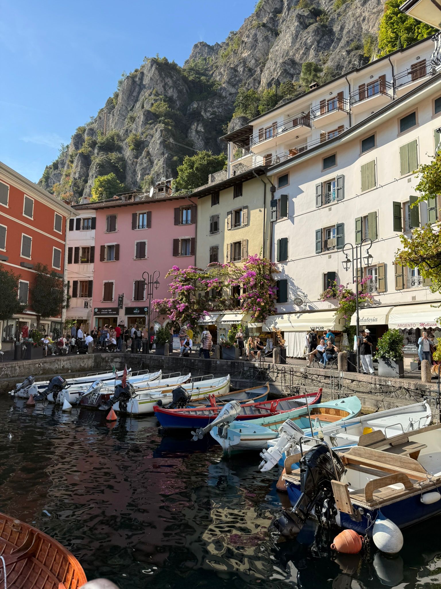 Colourful lakeside village with small boats moored in harbour, Lake Garda, Italy