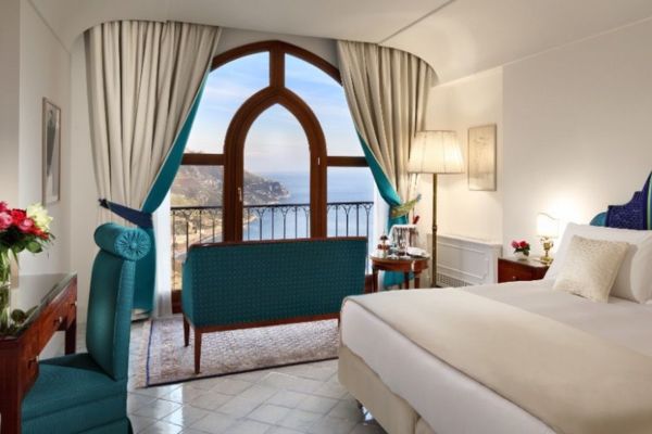Elegant guest room at Palazzo Avino with Gothic arched window and sea views over the Amalfi Coast